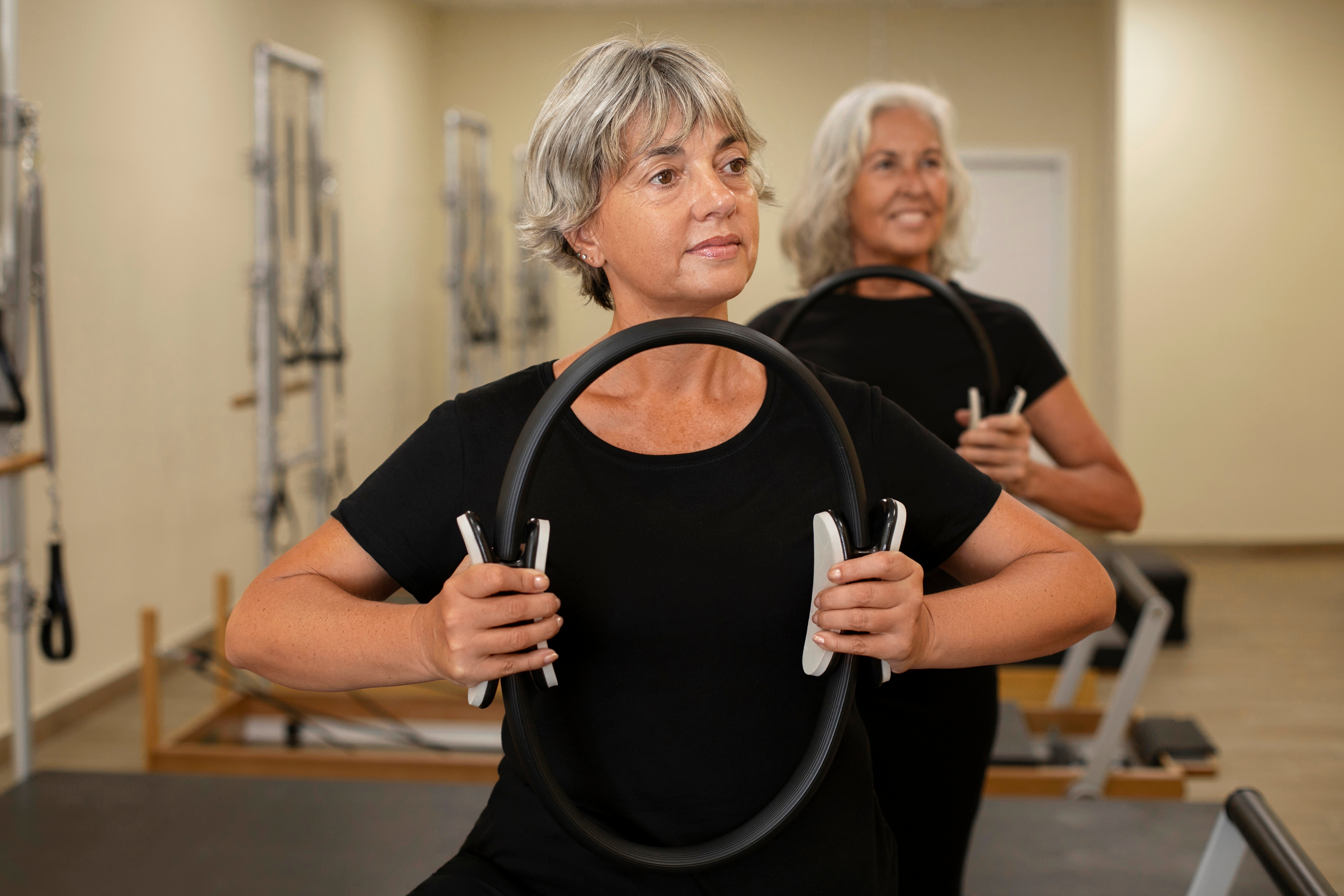 medium-shot-senior-women-pilates-reformer-class